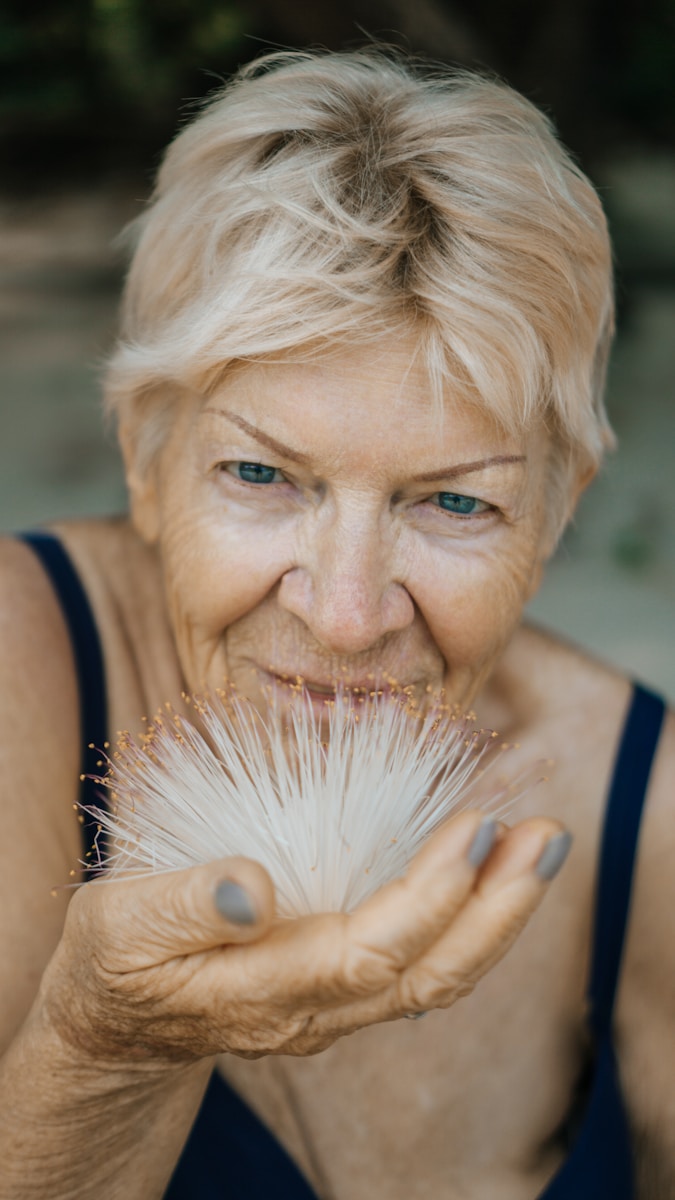 woman holding white-petaled flower